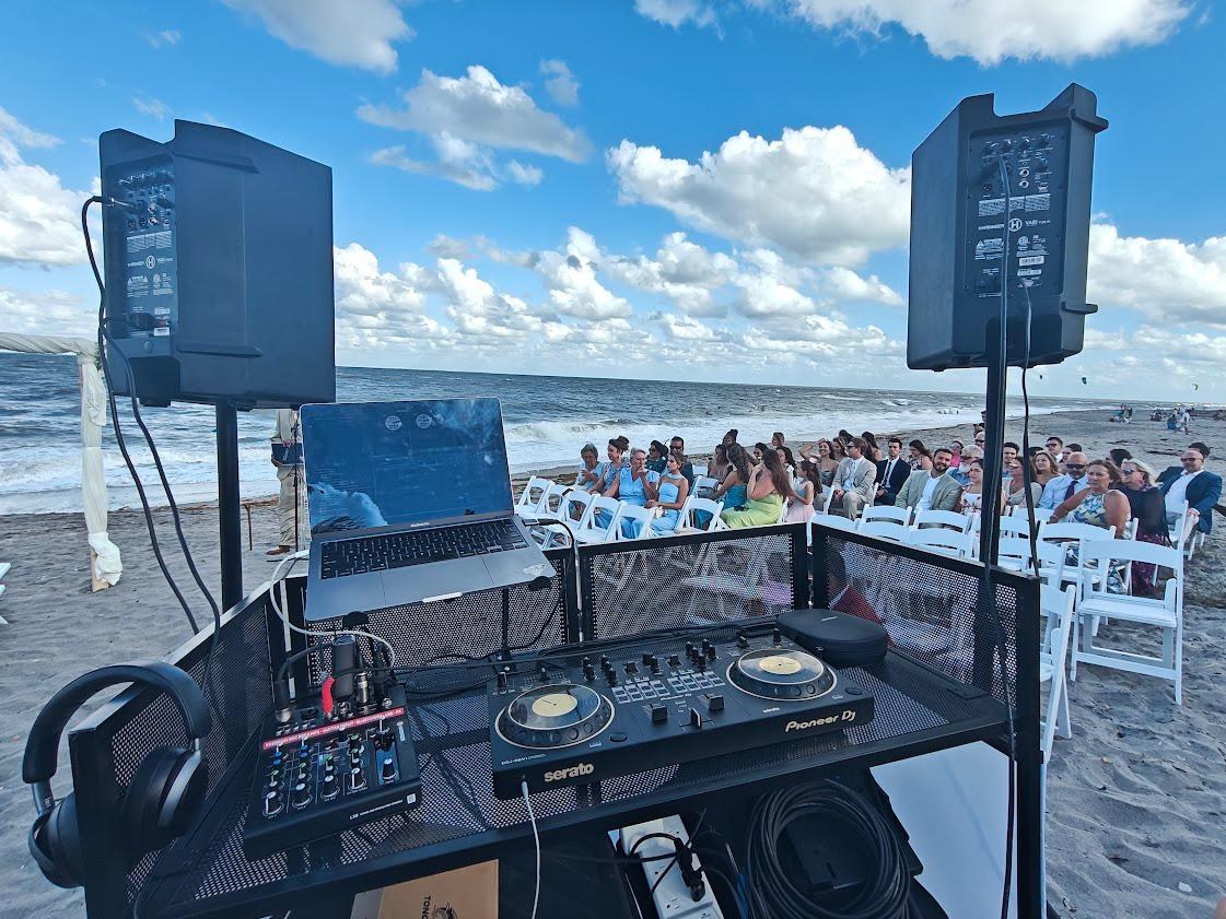 DJ setup overlooking a beach wedding ceremony